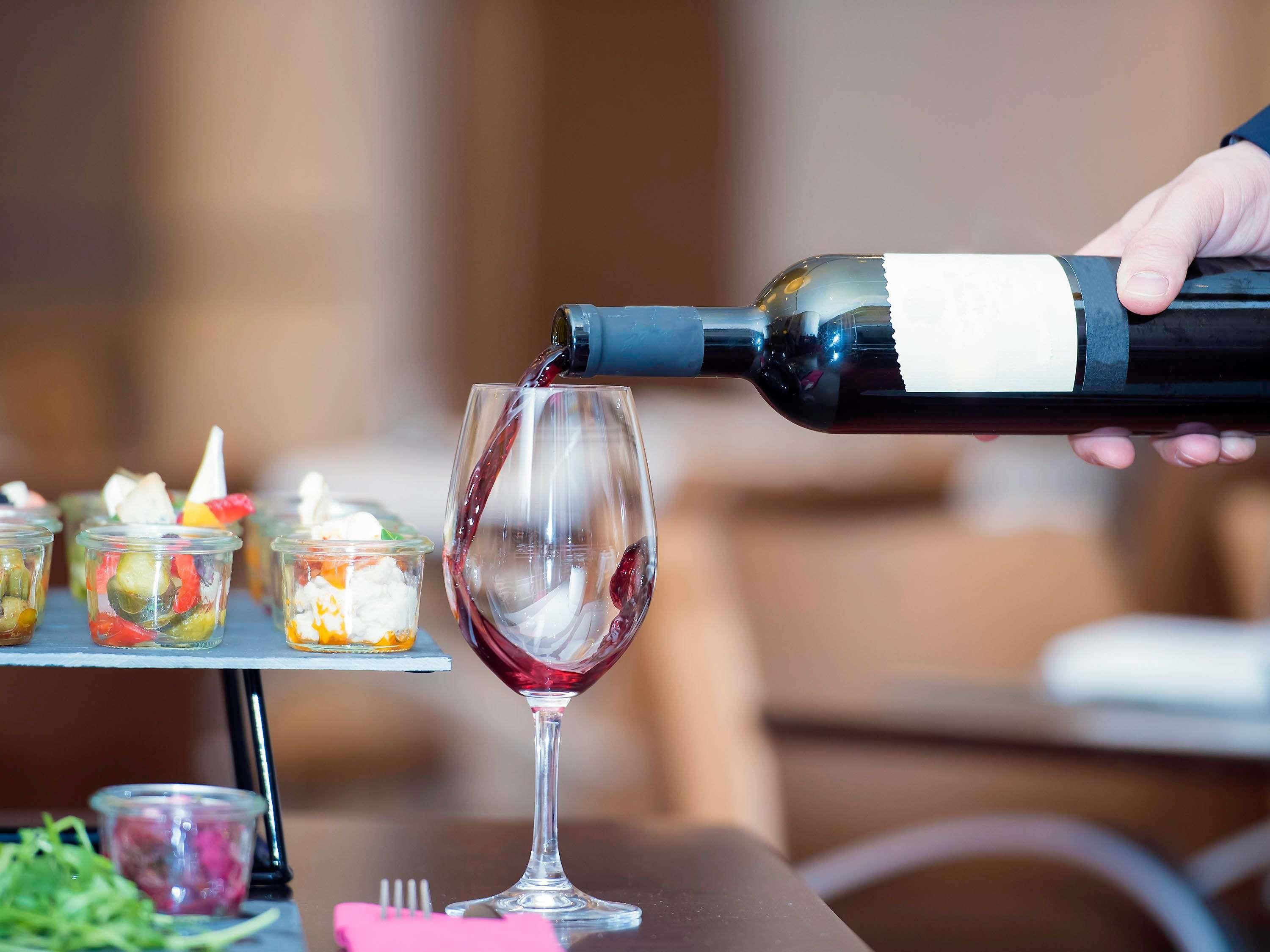 Rotwein wird in ein Glas gegossen.