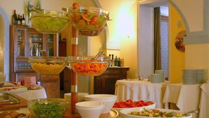 A buffet setup with various food items and a wine display. - Hotel Villa Picena (Colli del Tronto)