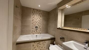 Un baño moderno con bañera, inodoro y lavamanos.