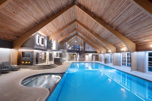An indoor swimming pool with a wooden ceiling and a curved design.