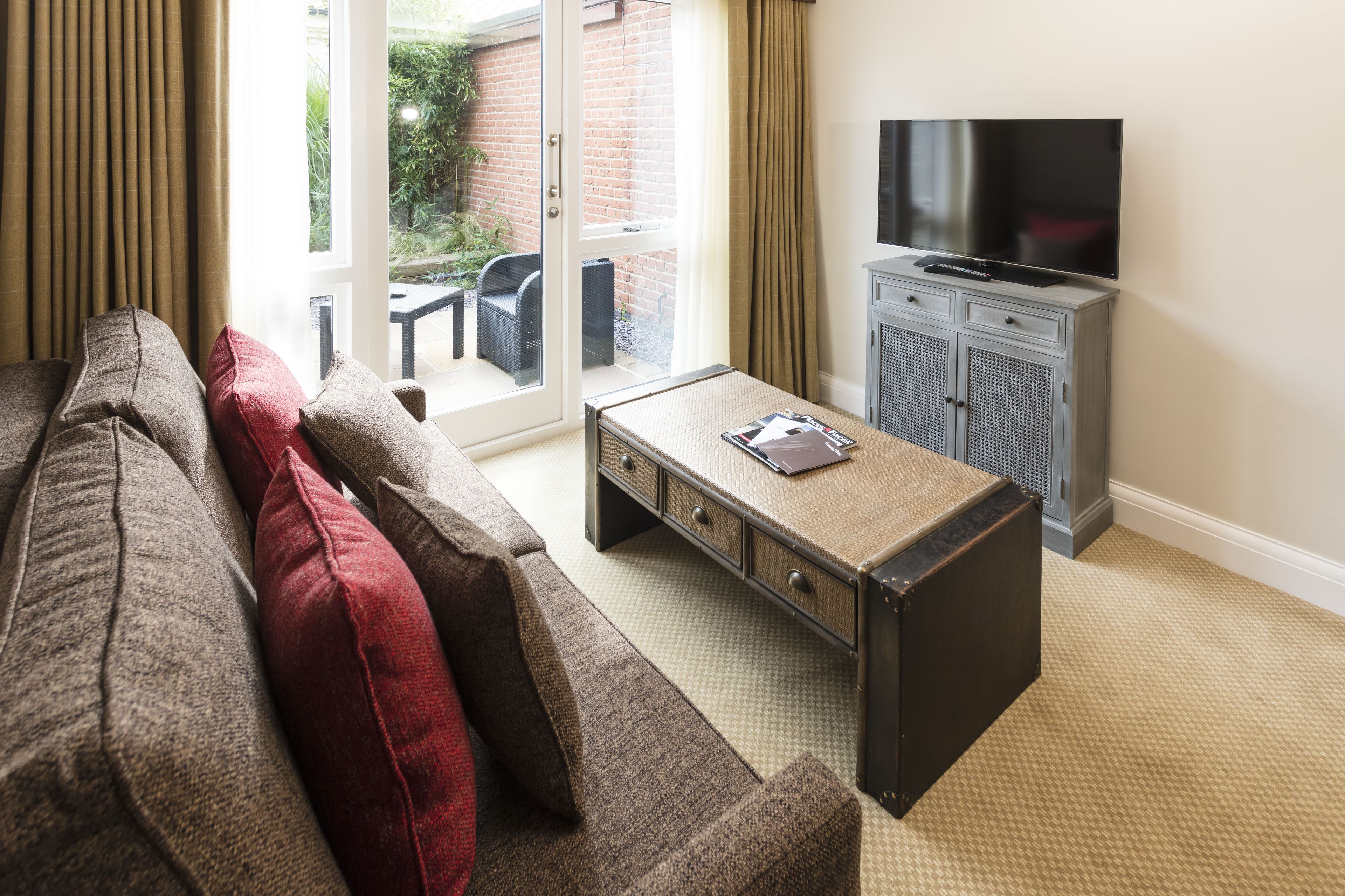 A living room with a sofa, a coffee table, a television, and a cabinet.