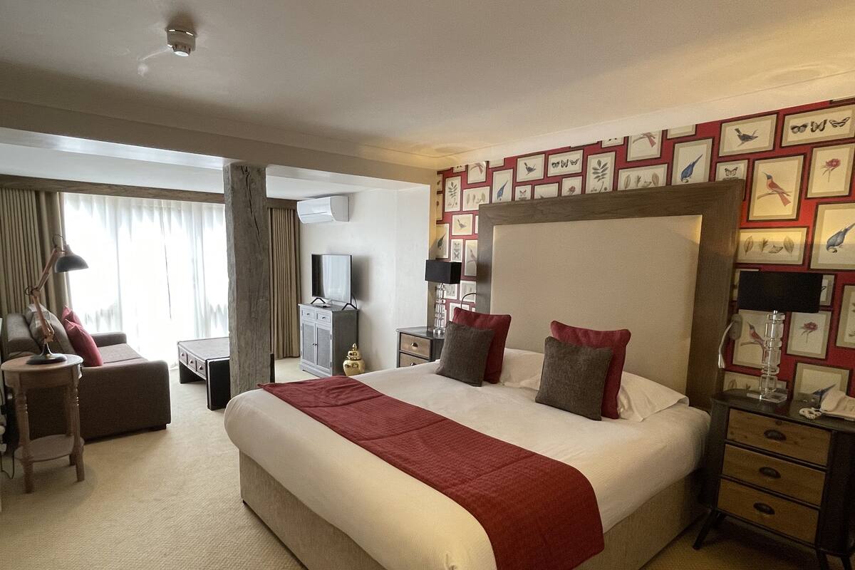 Een hotelkamer met een groot bed, een bureau, een stoel en een televisie.