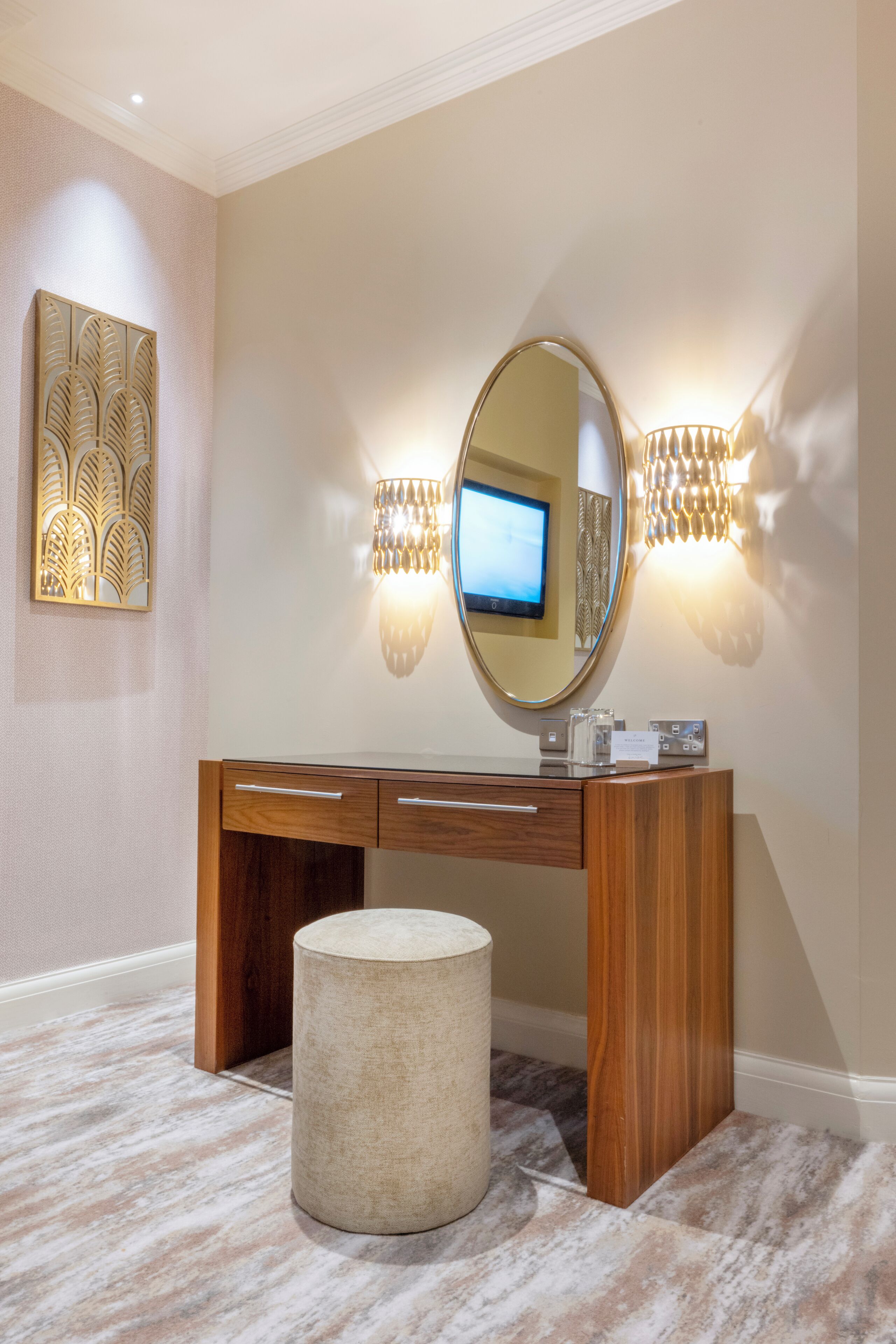 A modern bathroom with a wooden vanity, a round mirror, and two wall-mounted lights.