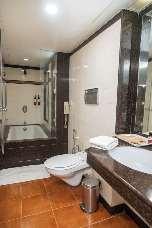 Un baño moderno con bañera, inodoro y ducha.