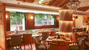 En restaurang med träinredning, bekväma sittplatser och en kristallkrona.