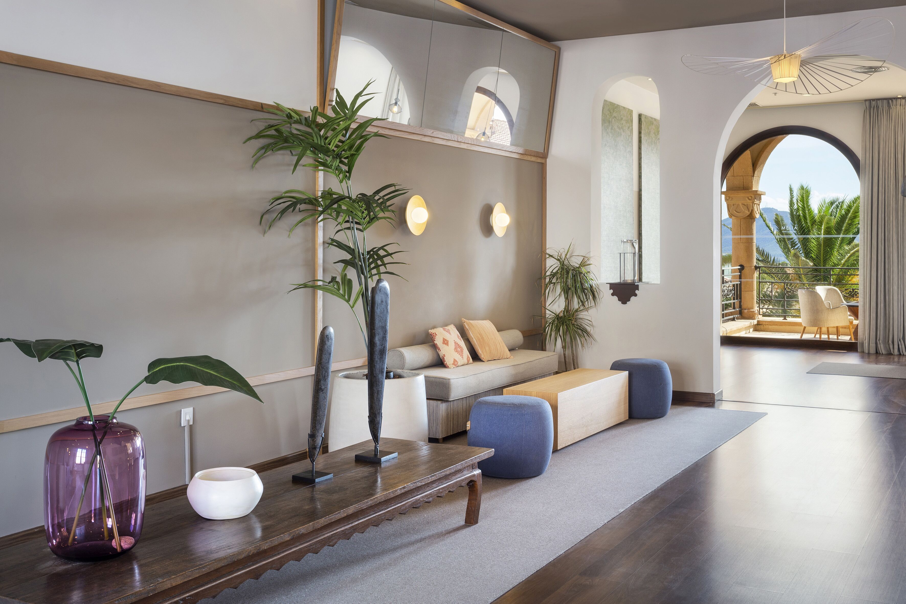 Una sala moderna con un sofá, una mesa de centro y plantas decorativas.