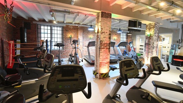 A gym with treadmills, stationary bikes, and weight machines. - Hotel Sprenz (Oldenburg)