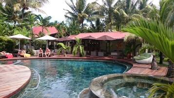 Una piscina al aire libre, sillones reclinables de piscina