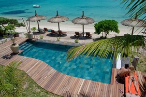 Una piscina al aire libre, sillones reclinables de piscina