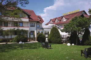 A hotel with a red-tiled roof, a covered outdoor seating area, and a well-maintained lawn with outdoor furniture. - Hotel Empfinger Hof, Sure Hotel Collection by Best Western (Empfingen)
