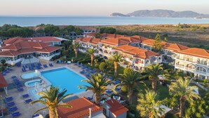 Um resort com piscina, espreguiçadeiras e vista para o mar.