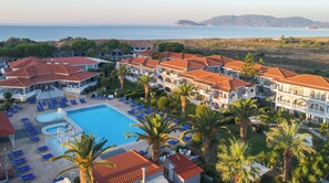 A resort with a swimming pool, sun loungers, and a view of the sea. - Golden Sun (Zakynthos)