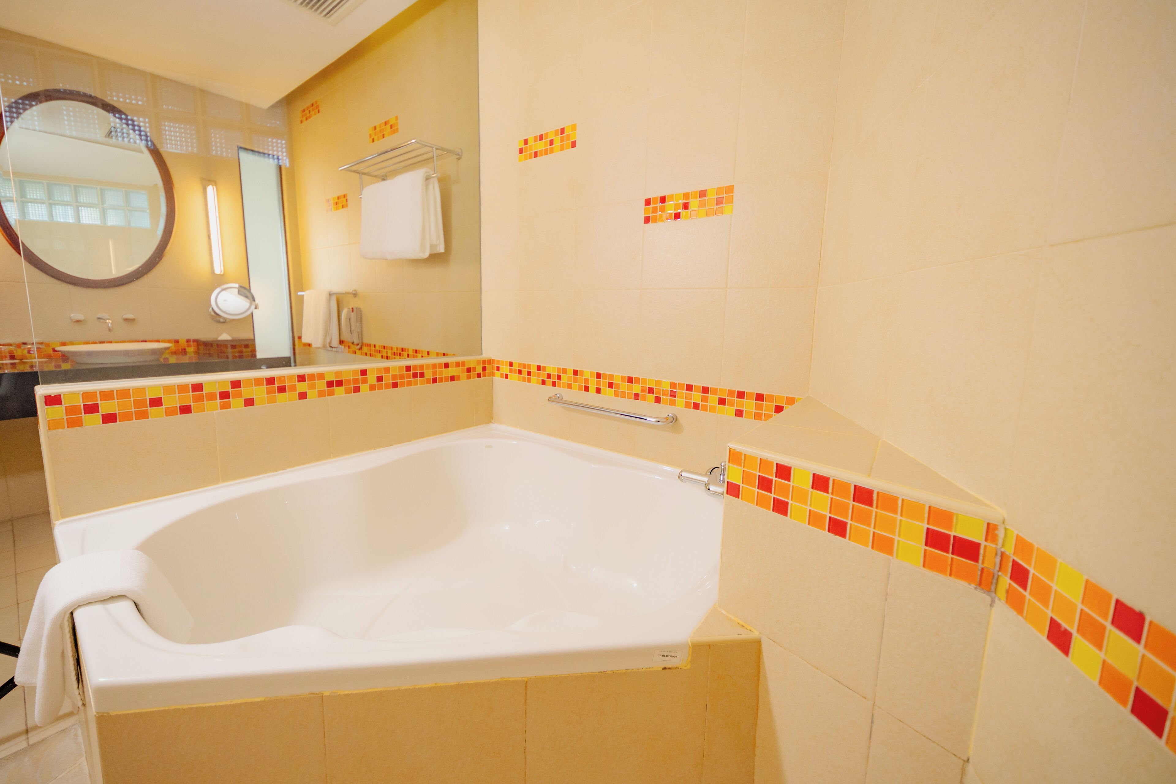 Ein Badezimmer mit einer Badewanne, einem Waschbecken, einem Spiegel und einem Handtuchhalter.