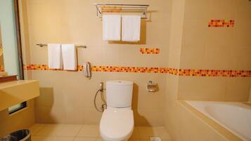 Un baño con inodoro, bañera, ducha y secador de manos.