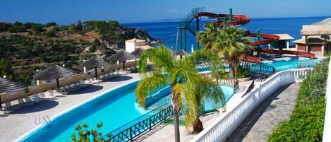 Alberca techada, alberca al aire libre y sombrillas en la alberca