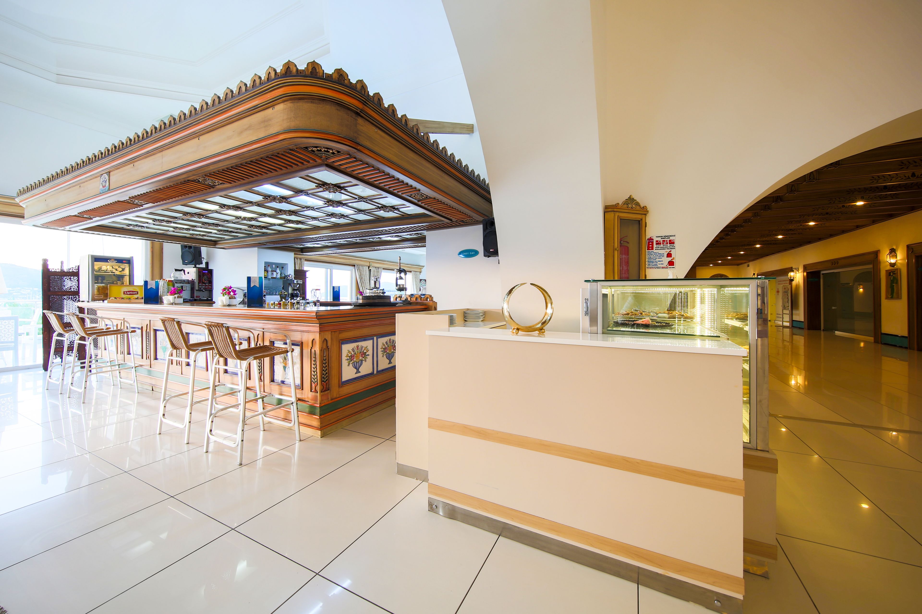Un moderno vestíbulo de hotel con mostrador de recepción, zona de bar y asientos.
