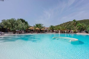 Una piscina al aire libre de temporada, una piscina infinita, sombrillas
