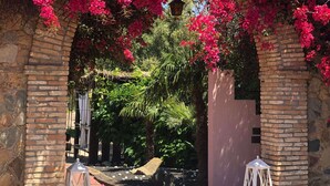 A brick archway with vibrant pink bougainvillea flowers. - Hotel Il Monastero (Quartu Sant'Elena)