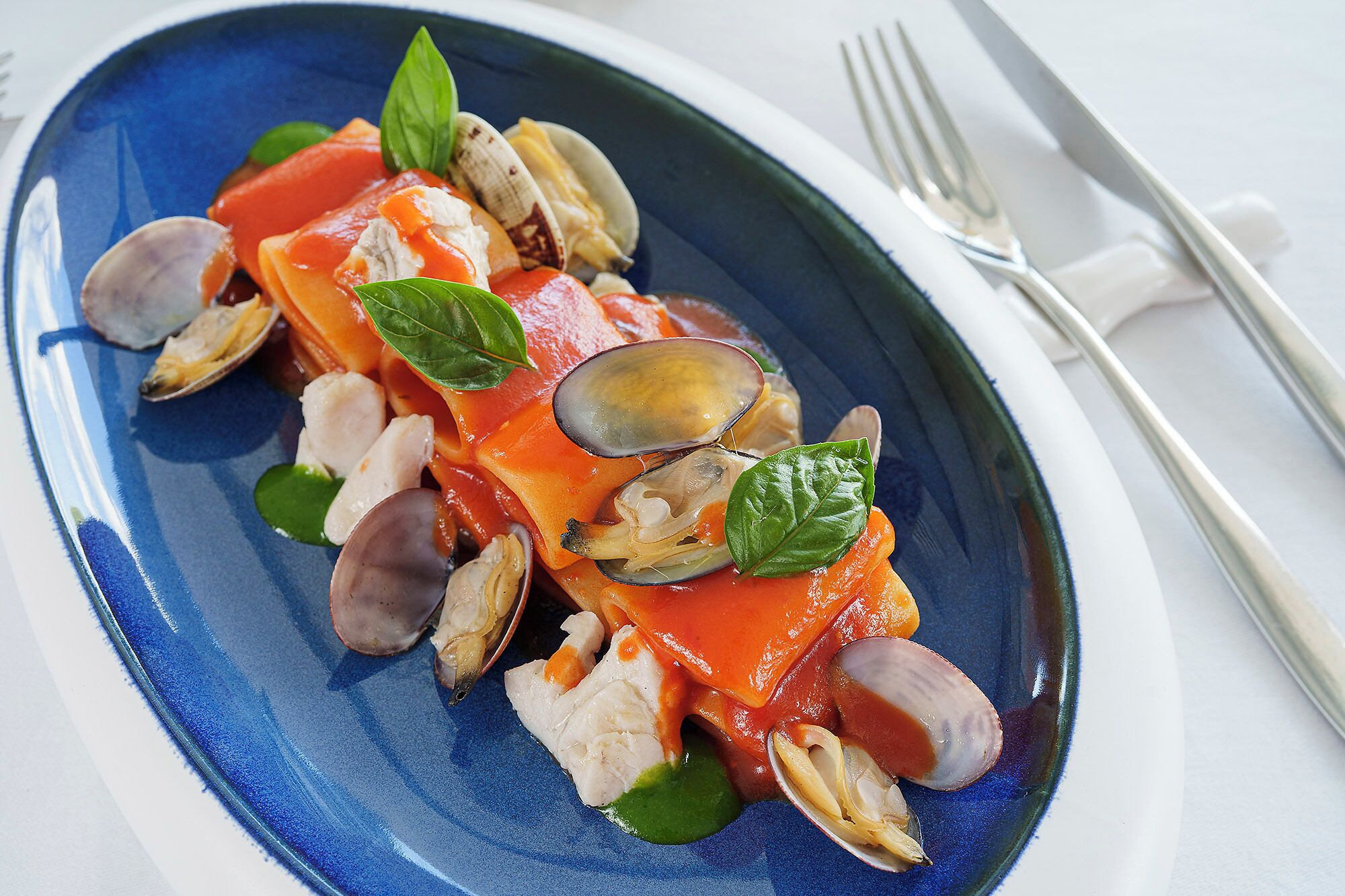 Un plato de mariscos con almejas y tomates.