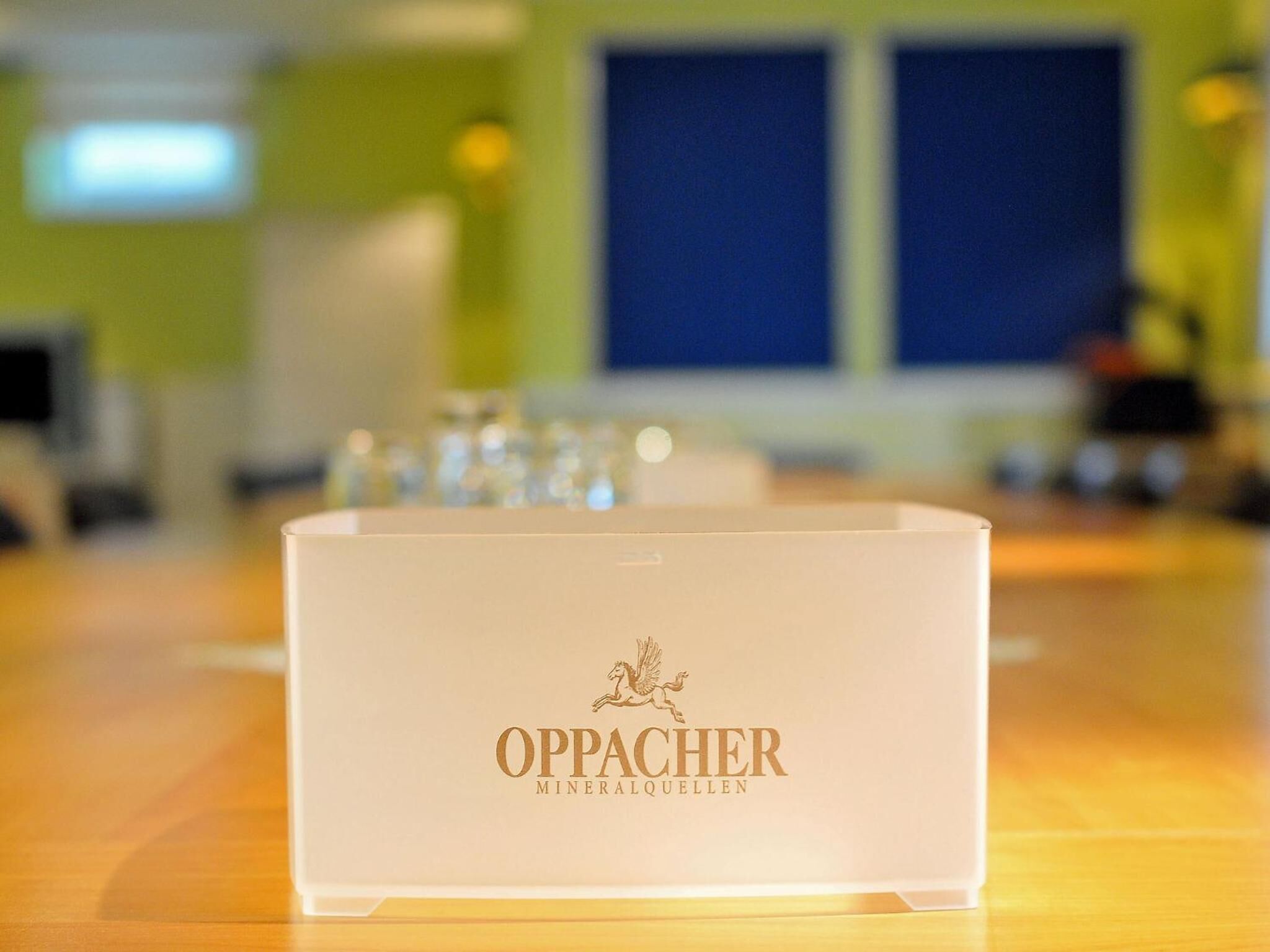 A white box with the text "OPPACHER MINERALQUELLEN" on a wooden surface.