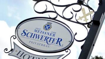 Une enseigne d’hôtel portant le nom « Sei Meissner Schwertier » et le mot « HÔTEL » en dessous.