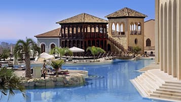 Relax by the resort's central pool surrounded by lounge chairs and umbrellas.