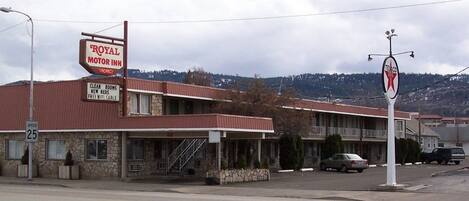 A motel with a sign advertising 'Royal Motor Inn' and 'Clean Rooms, New Beds, Free WiFi Cable'.