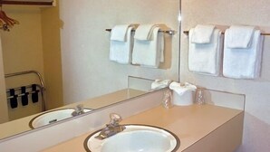 Une salle de bain équipée d’un lavabo, d’un miroir et d’un porte-serviettes.