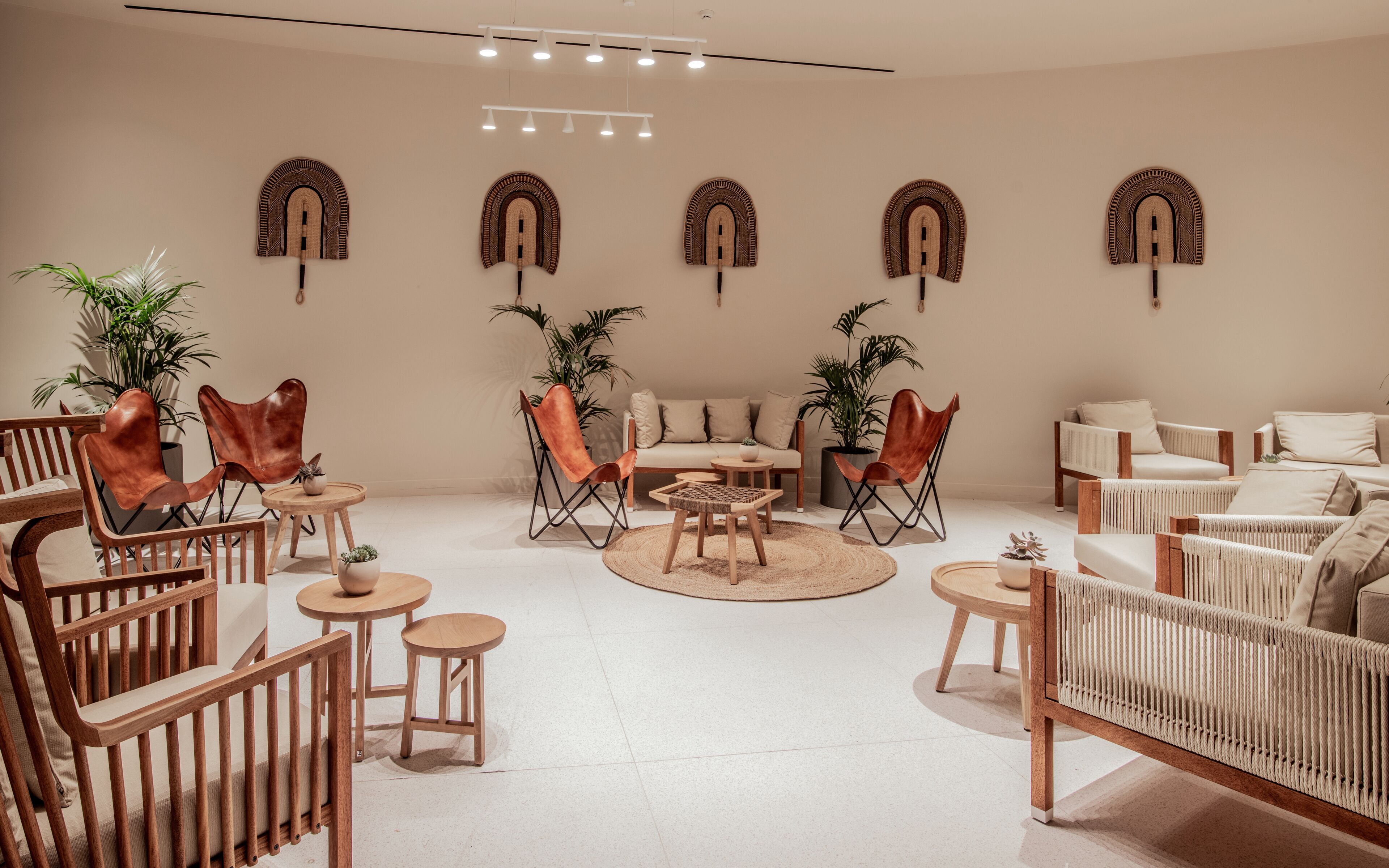 A modern lounge area with leather chairs, a sofa, and a round coffee table.