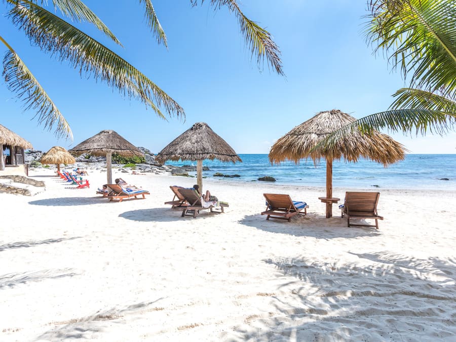 Aan het strand, wit zand, parasols, strandlakens