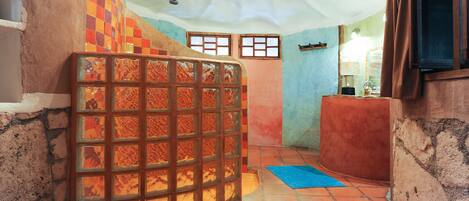 A room with a tiled floor, a large window with a view, and a wooden door.