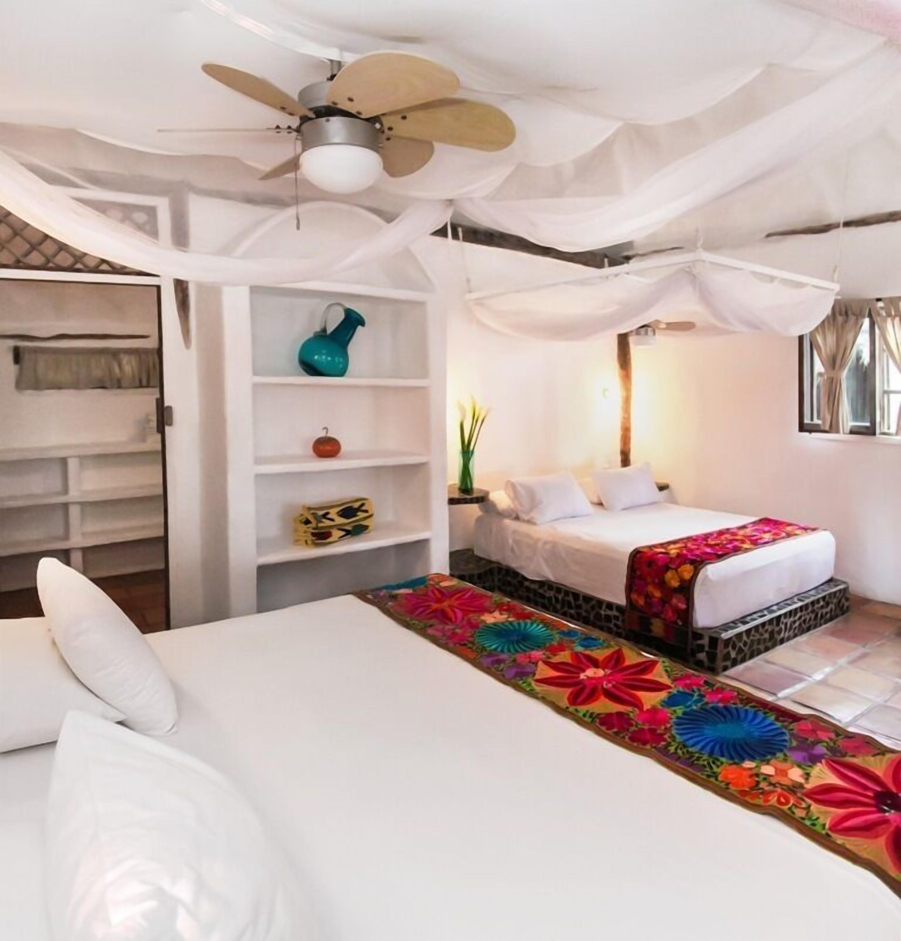 A bedroom with a bed, a nightstand, a wardrobe, and a ceiling fan.