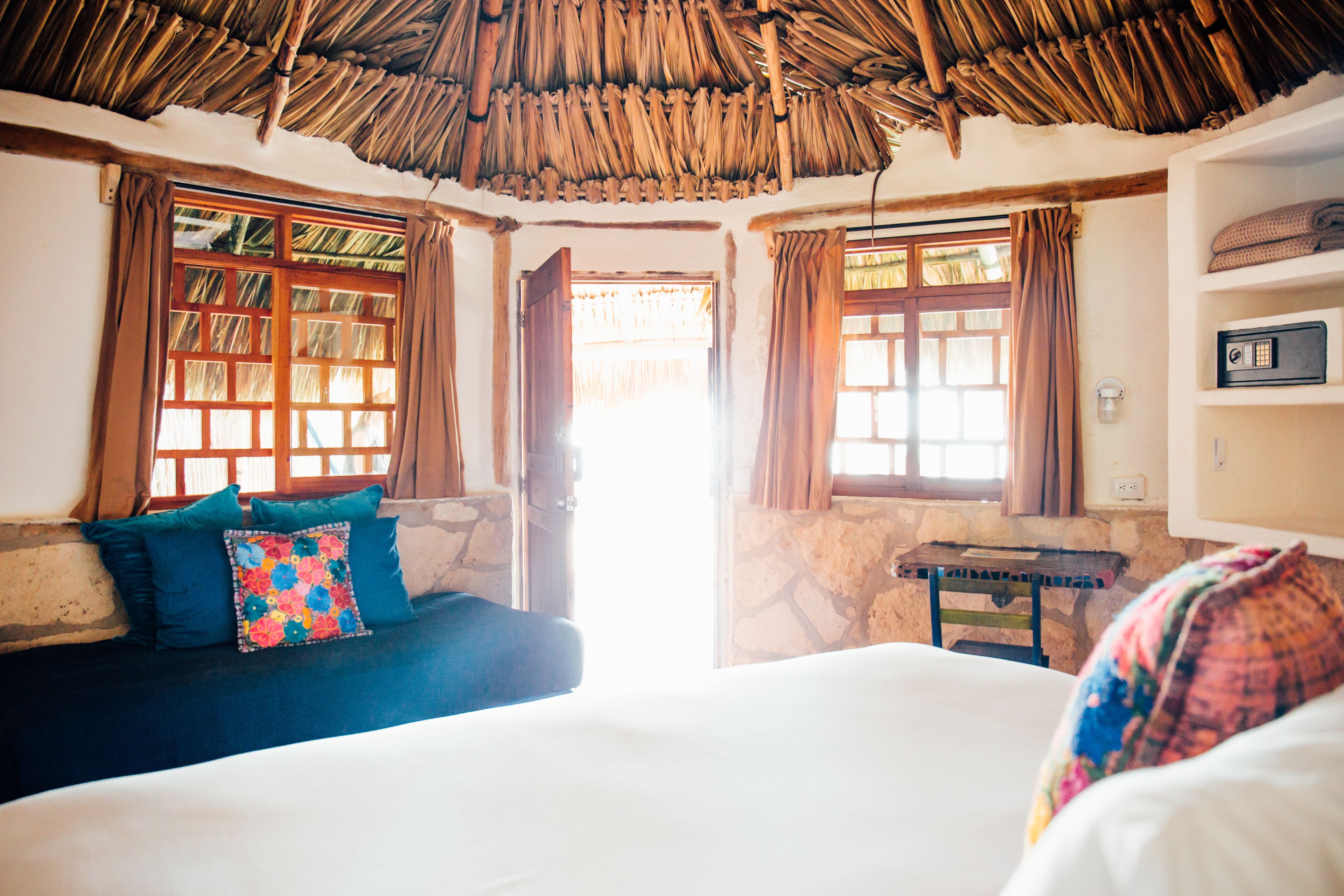 A room with a bed, a sofa, a small table, and a radio.