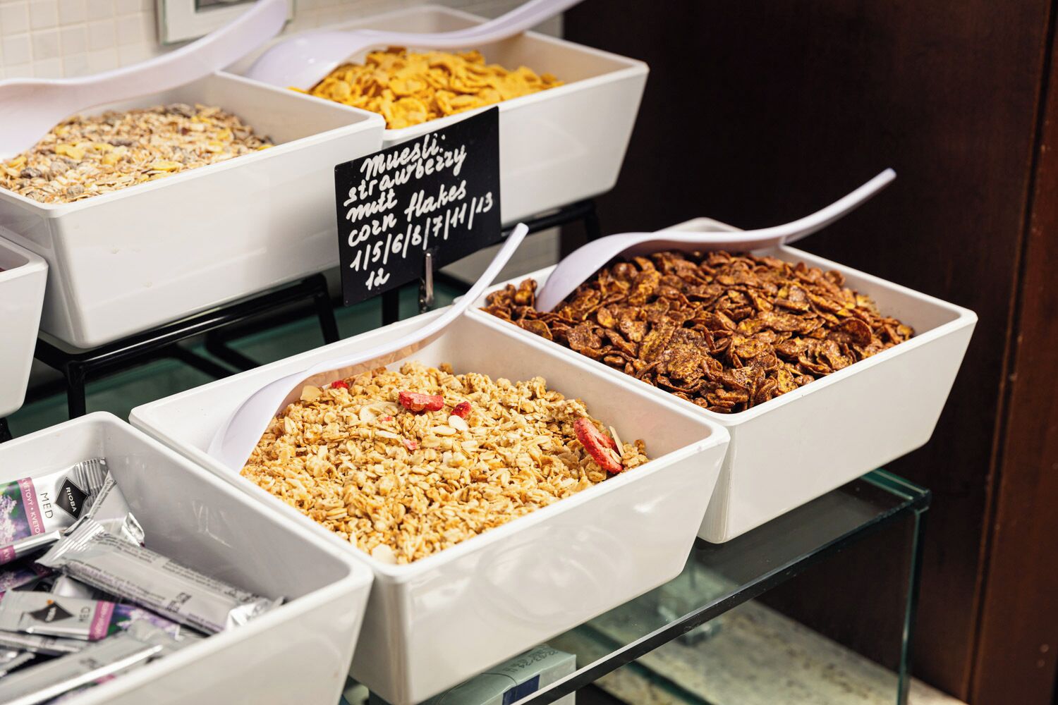 Buffet de desembre amb diverses opcions de cereals en plats blancs.