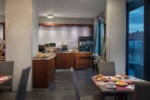 Un comedor de hotel moderno con una isla central, barra y asientos.