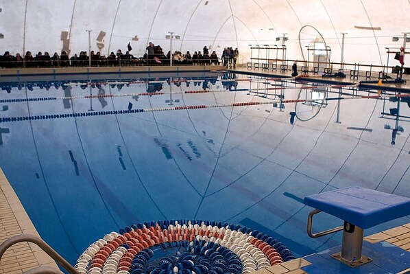 Piscina interior com faixas delimitadas e área para espectadores.