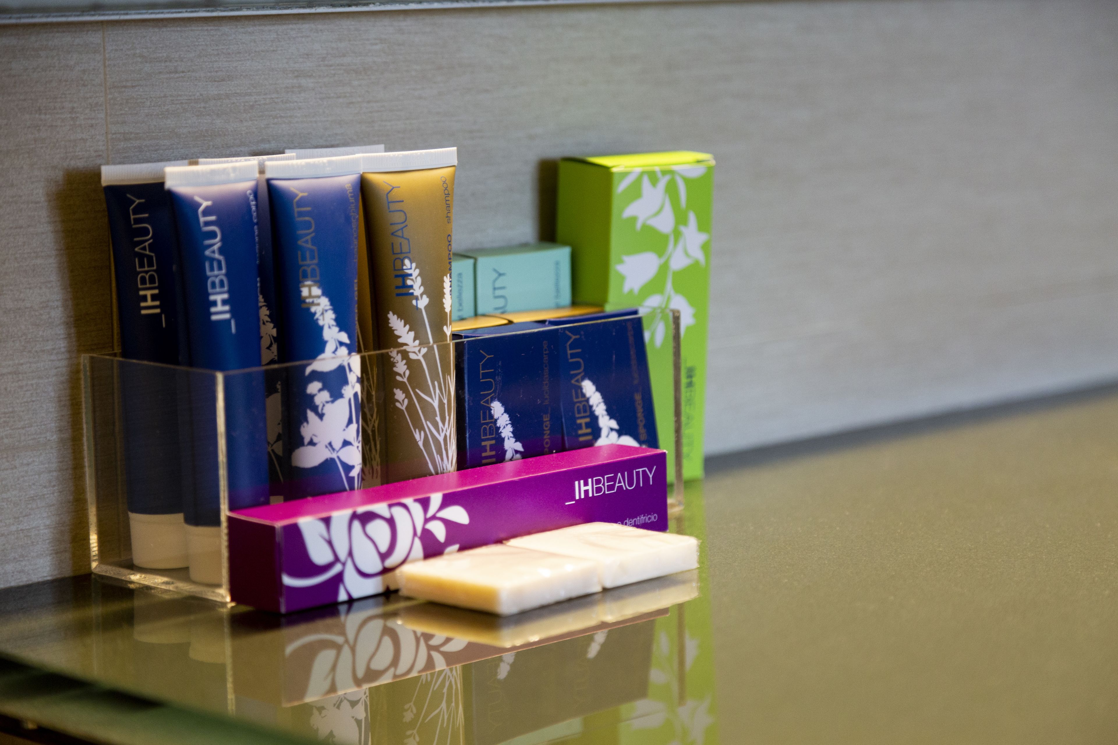 A display of various beauty products on a reflective surface.