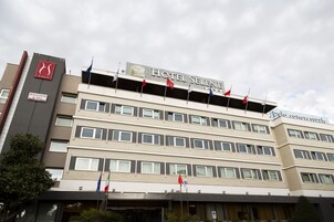 Um hotel de vários andares com uma placa que diz "HOTEL SELENT".