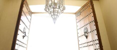 A room with a large, ornate ceiling medallion and a hanging chandelier.