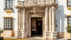 A building with ornate architectural details, including a decorative entrance and columns. - Palacio Marques De La Gomera (Osuna)