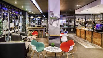 A modern bar area with seating, a bar counter, and a view of the cityscape.