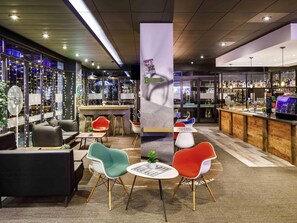 A modern bar area with seating, a bar counter, and a view of the cityscape. - ibis Bristol Centre (Bristol)