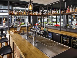 A bar area with multiple liquor bottles, a beer tap, and a coffee machine. - ibis Bristol Centre (Bristol)