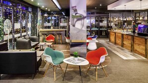 A modern bar area with seating, a bar counter, and a view of the cityscape. - ibis Bristol Centre (Bristol)