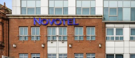 A Novotel hotel with a modern facade, large windows, and a prominent signage.