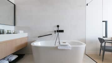 A modern bathroom with a freestanding bathtub, a wooden vanity, and a glass shower enclosure.