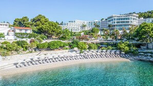 Et kysthotel med havudsigt, krystalklart turkis vand og en blanding af moderne og traditionel arkitektur.