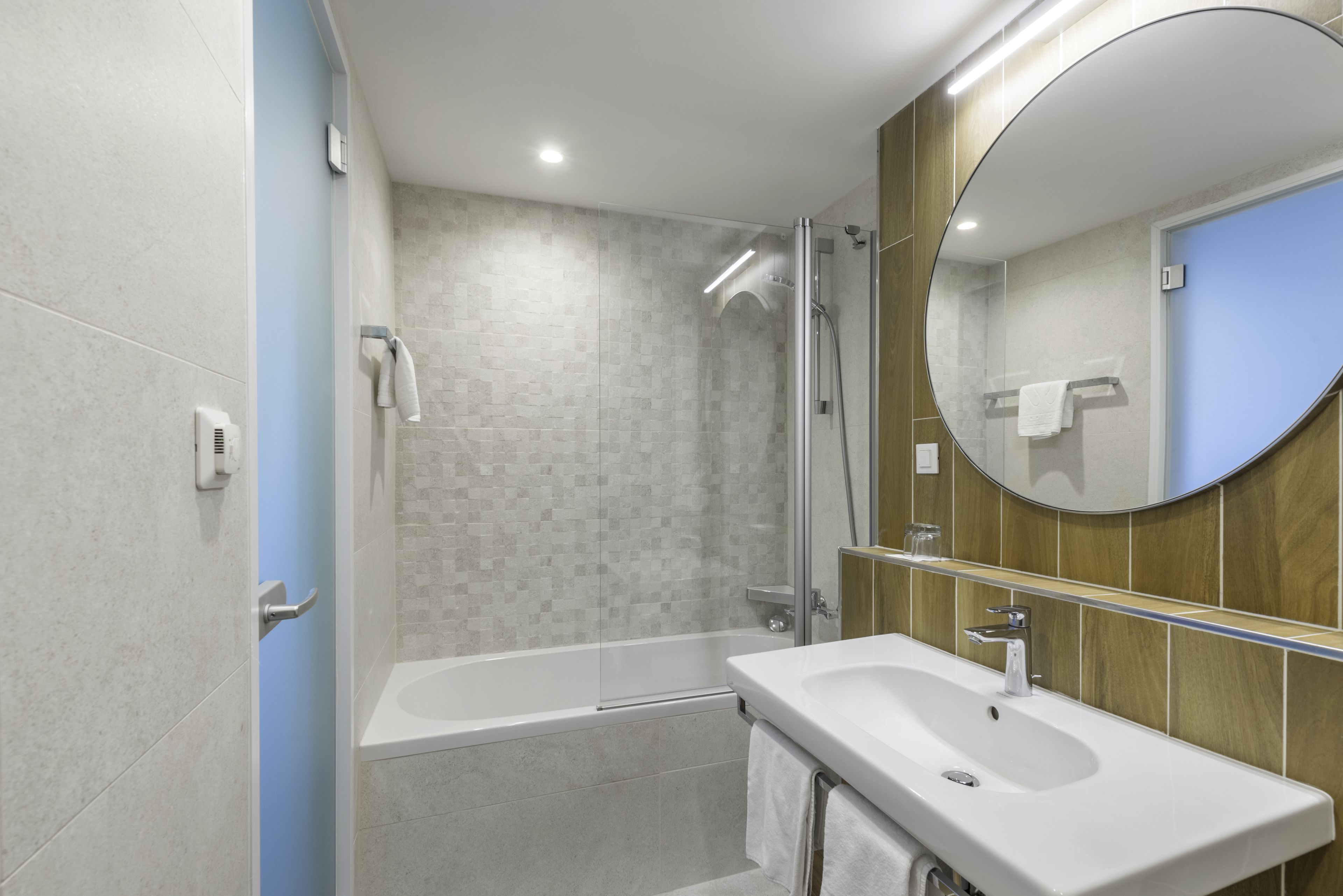 A modern bathroom with a bathtub, a sink, and a shower.