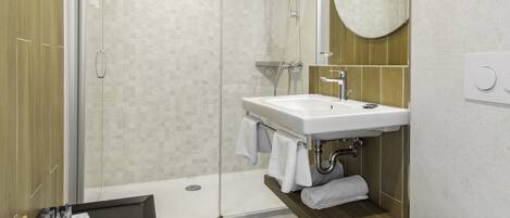 A modern bathroom with a shower, toilet, and sink.
