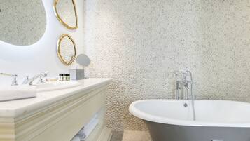 Ein modernes Badezimmer mit einer freistehenden Badewanne, einem Waschtisch mit Spiegel und einer Wand mit Struktur.